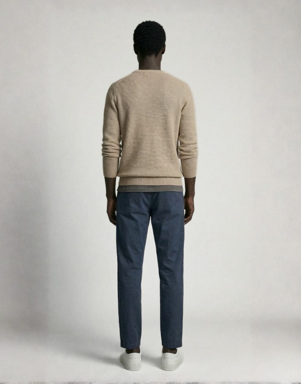 Textured Beige Knit Sweater with Relaxed Blue Trousers and Clean White Sneakers